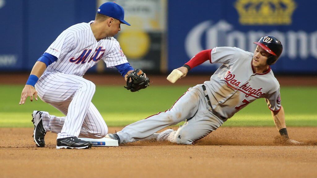 Washington Nationals shortstop Trea Turner steals second base as New York Mets second baseman Joe Panik applies the tag.