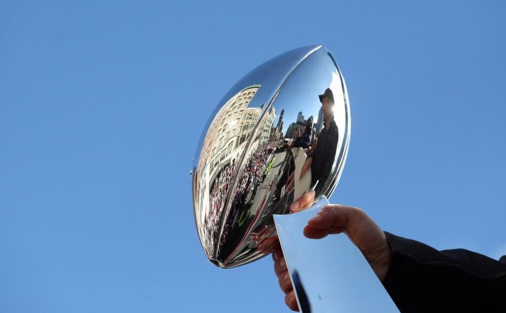 The Lombardi Trophy is hoisted in the air during the Patriots parade after winning Super Bowl LIII.